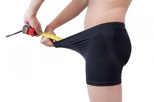 A man measures a penis with a tape measure