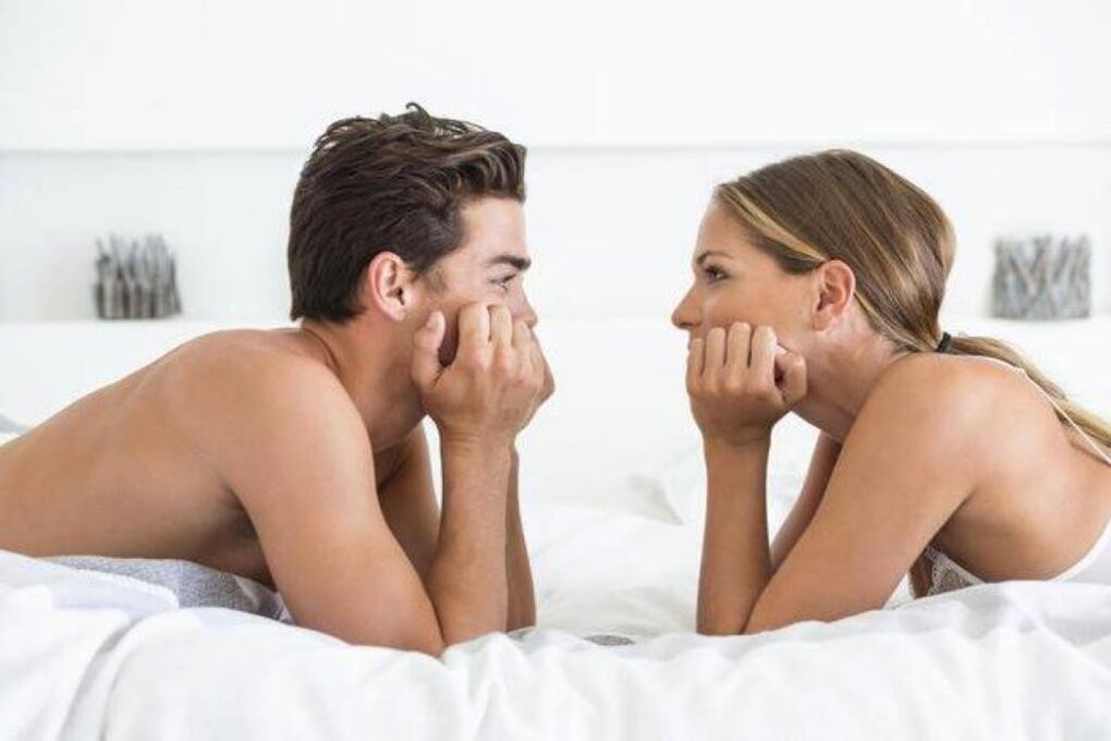a woman in bed with a man with an enlarged penis
