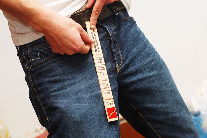 man measuring penis before enlarging it